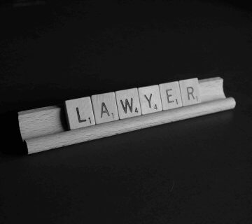 Letter tiles on a rack spell out the word "LAWYER" against a dark background, subtly prompting viewers to consider: When to Hire a Personal Injury Lawyer?. - Ghassemi Law Group Letter tiles on a rack spell out the word "LAWYER" against a dark background, subtly prompting viewers to consider: When to Hire a Personal Injury Lawyer?.