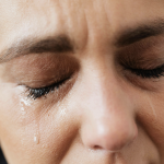Close-up of a person's face with eyes closed and tears running down their cheek, capturing the emotional distress in personal injury cases that can lead to recoverable damages. - Ghassemi Law Group Close up of a person's face with eyes closed and tears running down their cheek, capturing the emotional distress in personal injury cases that can lead to recoverable damages