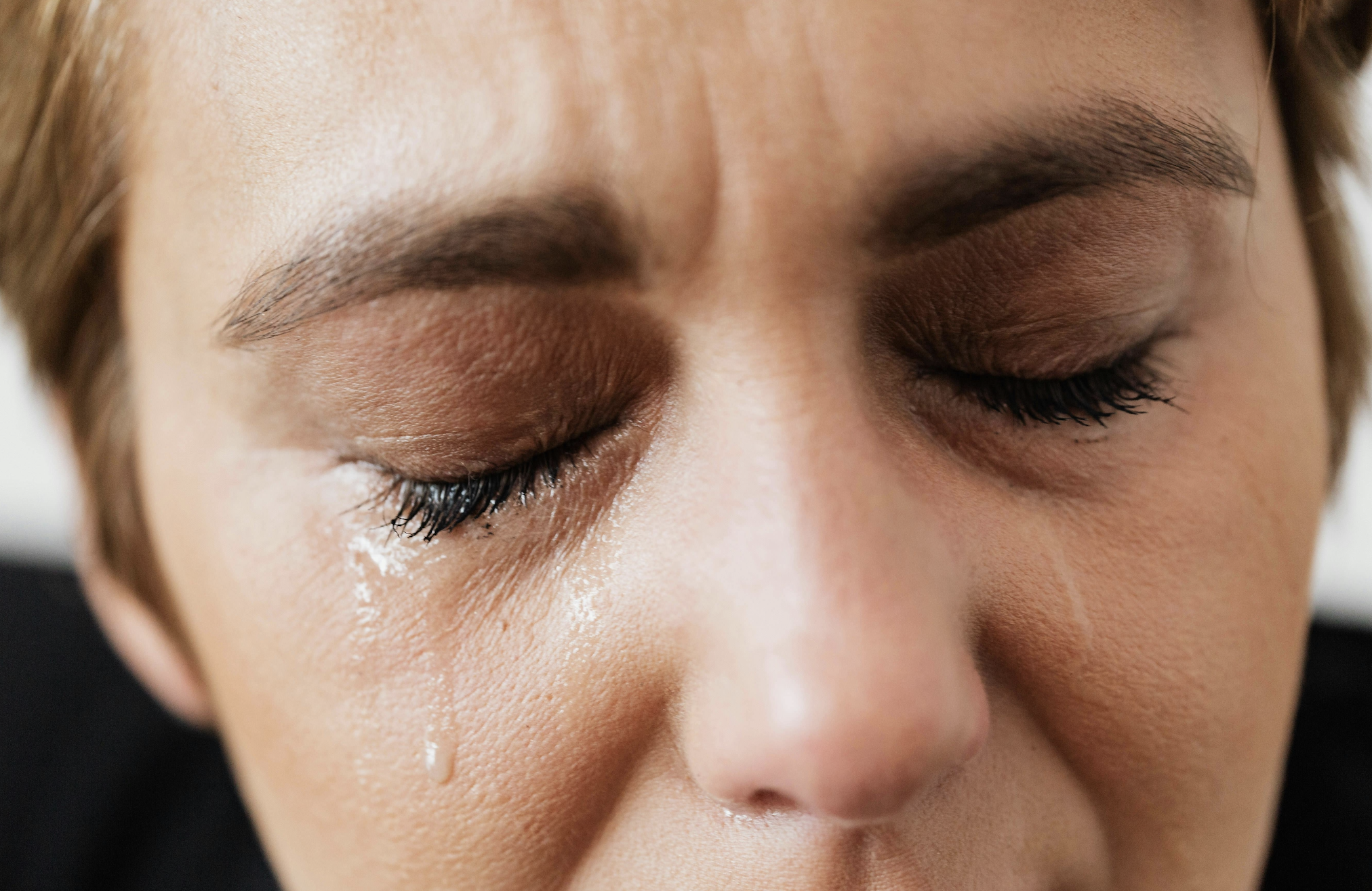 Close-up of a person's face with eyes closed and tears running down their cheek, capturing the emotional distress in personal injury cases that can lead to recoverable damages. - Ghassemi Law Group Close up of a person's face with eyes closed and tears running down their cheek, capturing the emotional distress in personal injury cases that can lead to recoverable damages