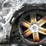Close-up of a burned car wheel and tire with fire damage and scorch marks on the surrounding car body—raising questions like, "Can I Sue for Pain and Suffering After a Car Accident in Irvine?. - Ghassemi Law Group Close up of a burned car wheel and tire with fire damage and scorch marks on the surrounding car body—raising questions like, "Can I Sue for Pain and Suffering After a Car Accident in Irvine?