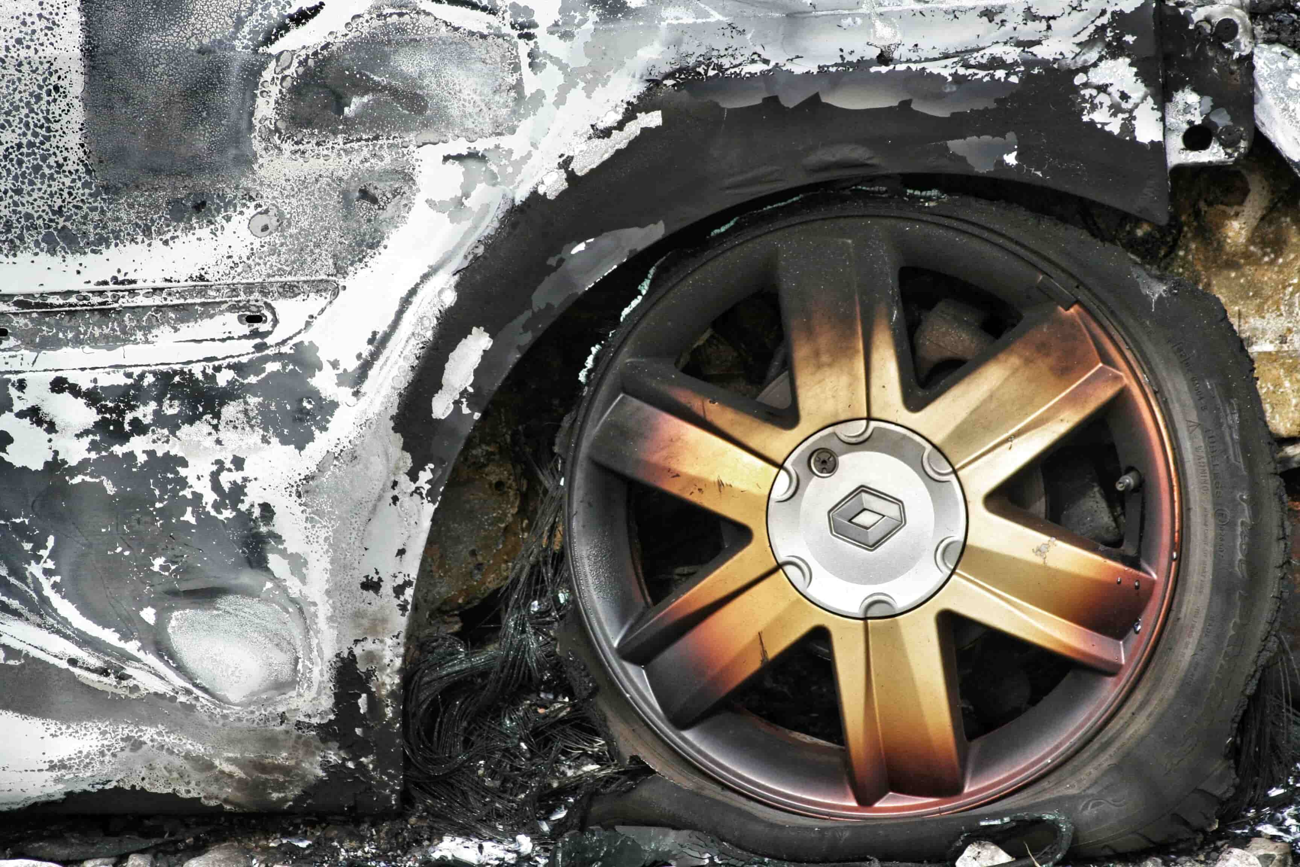 Close-up of a burned car wheel and tire with fire damage and scorch marks on the surrounding car body—raising questions like, "Can I Sue for Pain and Suffering After a Car Accident in Irvine?. - Ghassemi Law Group Close up of a burned car wheel and tire with fire damage and scorch marks on the surrounding car body—raising questions like, "Can I Sue for Pain and Suffering After a Car Accident in Irvine?