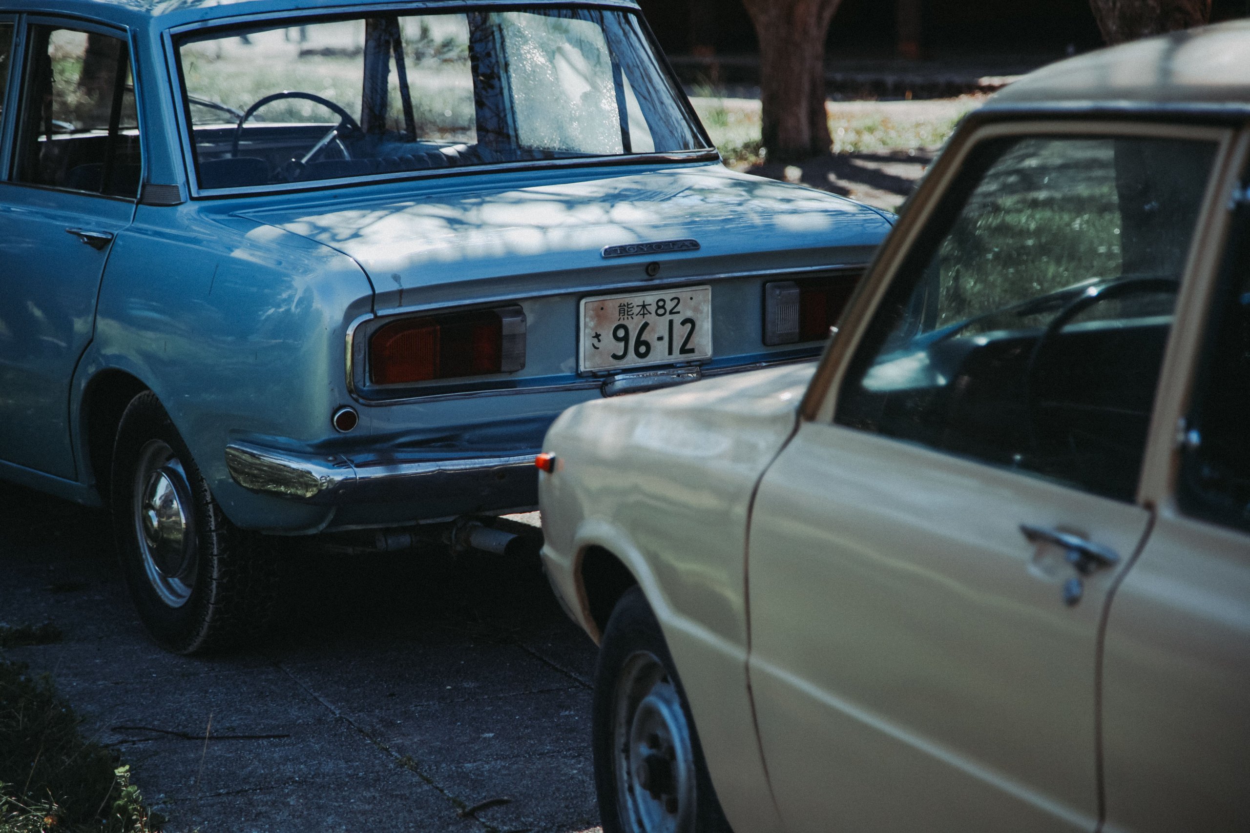 Two vintage cars, one blue and one beige, are parked closely together on a shaded outdoor surface—a potential scene for discussing how do I prove negligence in a car accident case in Irvine. The blue car’s rear and license plate are visible. - Ghassemi Law Group Two vintage cars, one blue and one beige, are parked closely together on a shaded outdoor surface—a potential scene for discussing how do I prove negligence in a car accident case in Irvine The blue car’s rear and license plate are visible